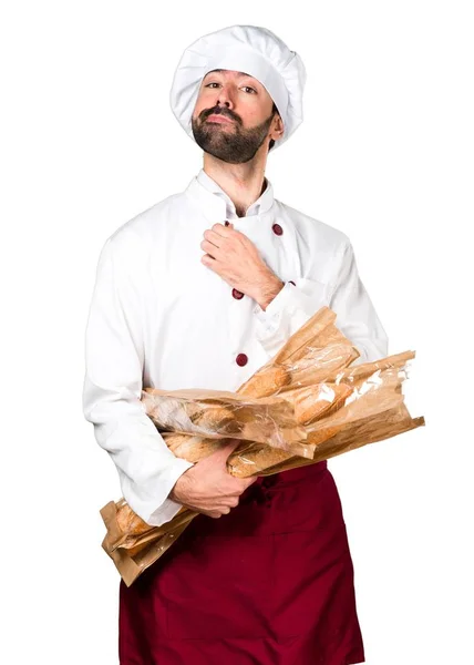 Feliz panadero joven sosteniendo un poco de pan —  Fotos de Stock