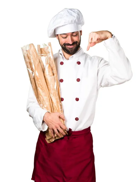 Młody piekarz trzyma chleb i skierowany w dół — Zdjęcie stockowe
