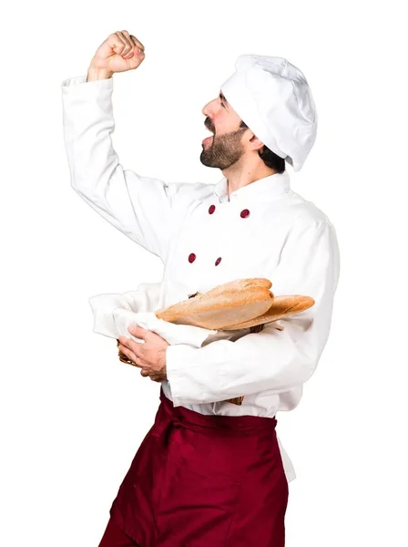 Szczęśliwy młody piekarz trzyma chleb — Zdjęcie stockowe