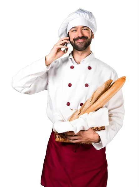 Młody piekarz trzyma chleb i mówić do telefonów — Zdjęcie stockowe