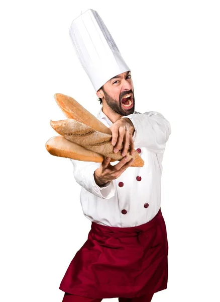 Sfrustrowany młody piekarz trzyma chleb — Zdjęcie stockowe