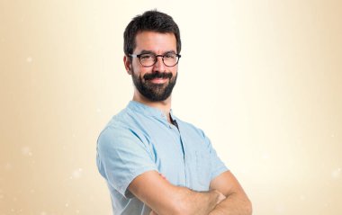 Yakışıklı adam kollarını ile koyu sarı arka plan üzerinde çarpı işareti