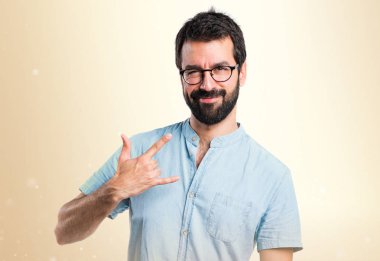 Yakışıklı adam yapma boynuz jest koyu sarı zemin üzerine