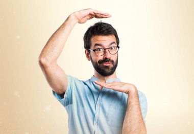 Yakışıklı adam yüzünü koyu sarı arka plan üzerinde duruluyor