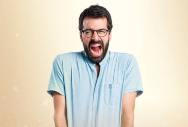 Koyu sarı zemin üzerine bağırarak kızgın yakışıklı adam