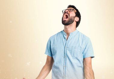 Koyu sarı zemin üzerine bağırarak kızgın yakışıklı adam