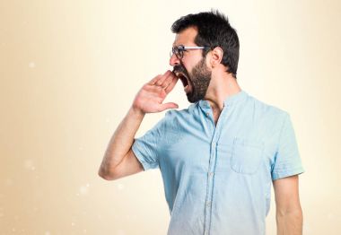 Koyu sarı zemin üzerine bağırarak kızgın yakışıklı adam