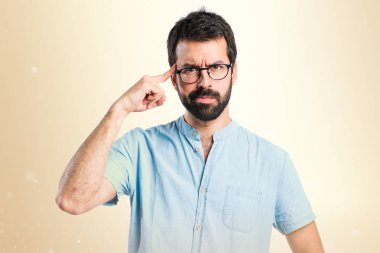 Koyu sarı arka plan üzerinde düşünme gözlüklü yakışıklı adam