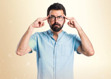 Koyu sarı arka plan üzerinde düşünme gözlüklü yakışıklı adam