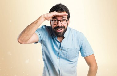 Bir şey Koyu sarı backgr gösterilen mavi gözlüklü yakışıklı adam