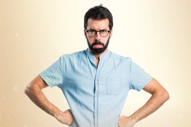 Koyu sarı zemin üzerine mavi gözlük ile üzgün yakışıklı adam