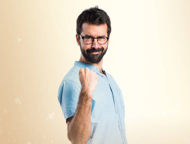 Koyu sarı zemin üzerine mavi gözlük ile şanslı yakışıklı adam