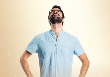 Koyu sarı zemin üzerine ararken mavi gözlüklü yakışıklı adam