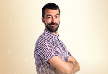 Yakışıklı adam kollarını ile koyu sarı arka plan üzerinde çarpı işareti