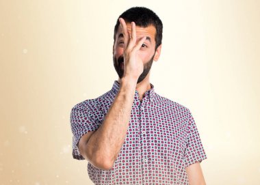 Koyu sarı arka plan üzerinde bir şaka yapan yakışıklı erkek