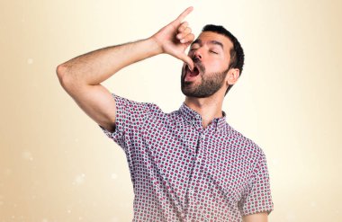 Koyu sarı zemin üzerine sarhoş jest yapan yakışıklı erkek