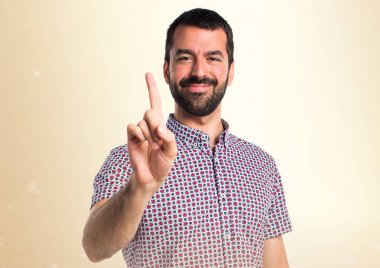 Yakışıklı adam bir koyu sarı arka plan üzerinde sayma