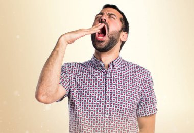 Yakışıklı adam koyu sarı zemin üzerine esneme