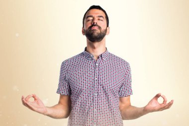 Koyu sarı zemin üzerine zen pozisyonundaki yakışıklı adam