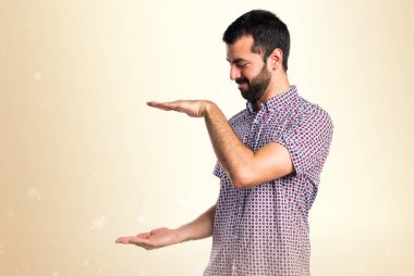 Bir şey Koyu sarı arka plan üzerinde tutan yakışıklı adam