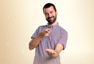 Bir şey Koyu sarı arka plan üzerinde tutan yakışıklı adam