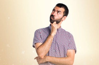 Yakışıklı adam koyu sarı arka plan üzerinde düşünme