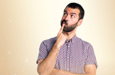 Yakışıklı adam koyu sarı arka plan üzerinde düşünme