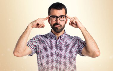 Koyu sarı arka plan üzerinde düşünme gözlüklü adam