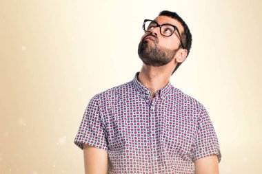 Koyu sarı zemin üzerine şüpheleri gözlüklü adam