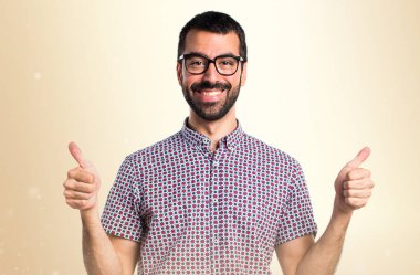 Koyu sarı zemin üzerine başparmak ile gözlüklü adam