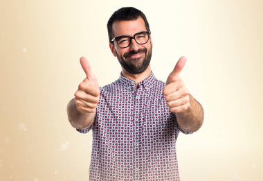 Koyu sarı zemin üzerine başparmak ile gözlüklü adam