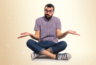 Koyu sarı arka plan üzerinde önemsiz jest yapma gözlüklü adam