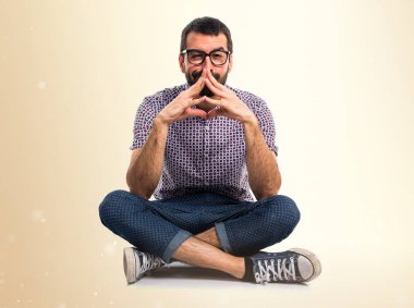 Koyu sarı arka plan üzerinde düşünme gözlüklü adam