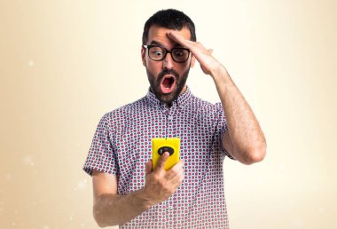 Koyu sarı zemin üzerine konuşmak için mobil gözlüklü adam