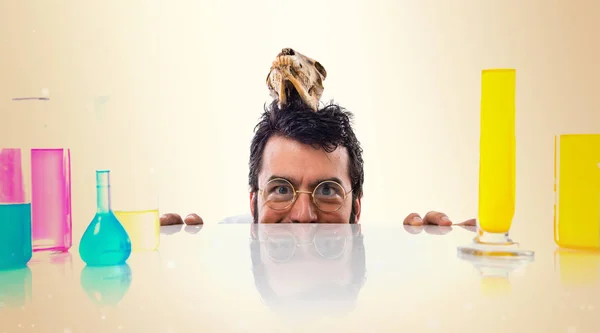 Homem cientista louco com crânio no fundo ocre — Fotografia de Stock