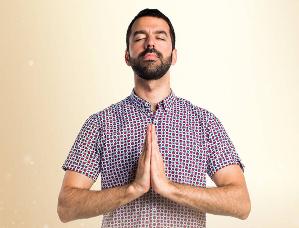 Handsome man in zen position on ocher background