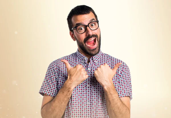 Mann mit Brille mit Daumen nach oben auf ockerfarbenem Hintergrund — Stockfoto