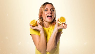 Limon koyu sarı arka plan üzerinde tutan güzel sarışın kadın