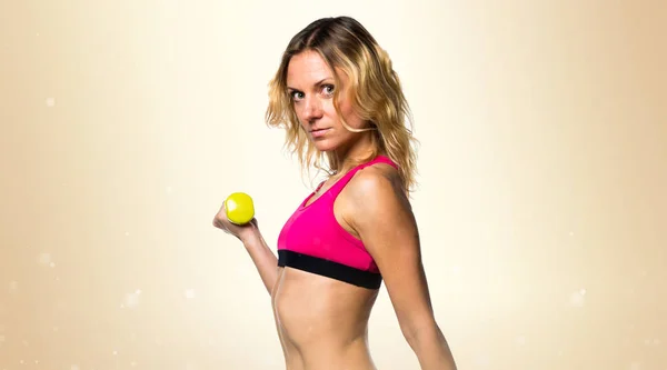Deporte mujer haciendo levantamiento de pesas sobre fondo ocre —  Fotos de Stock
