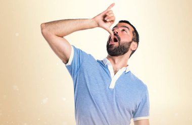 Adam mavi gömlek koyu sarı zemin üzerine sarhoş jest yapıyor