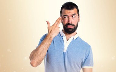 Adam koyu sarı zemin üzerine mavi gömlek yapma intihar hareketi ile