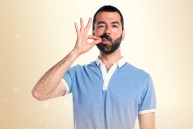 Adam koyu sarı zemin üzerine mavi gömlek yapma sessizlik hareketi ile