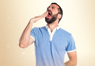 Adam mavi gömlek koyu sarı zemin üzerine esneme ile