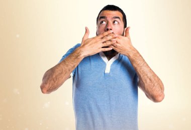 Adam mavi gömlek koyu sarı zemin üzerine sürpriz jest yapıyor