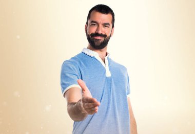 Mavi gömlekli bir anlaşma üzerinde koyu sarı arka plan ile adam