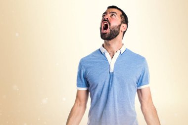 Mavi gömlek koyu sarı zemin üzerine bağırarak adamla