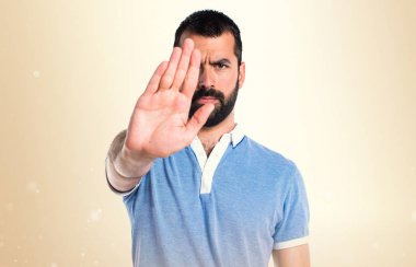 Adam mavi gömlek koyu sarı zemin üzerine kırmızı yapma