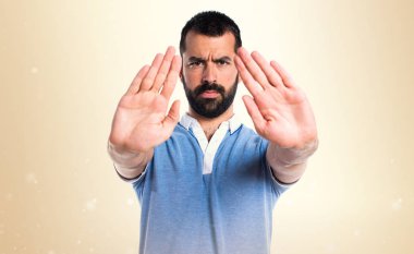 Adam mavi gömlek koyu sarı zemin üzerine kırmızı yapma