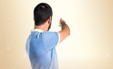 Adam mavi gömlek koyu sarı zemin üzerine işaret