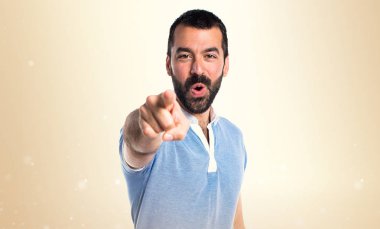 Mavi gömlek koyu sarı zemin üzerine açık işaret eden adamla